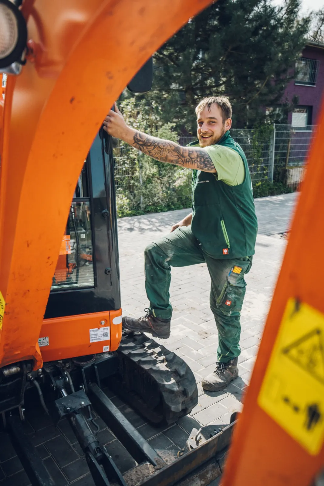 Mitarbeiter am Minibagger im Garten