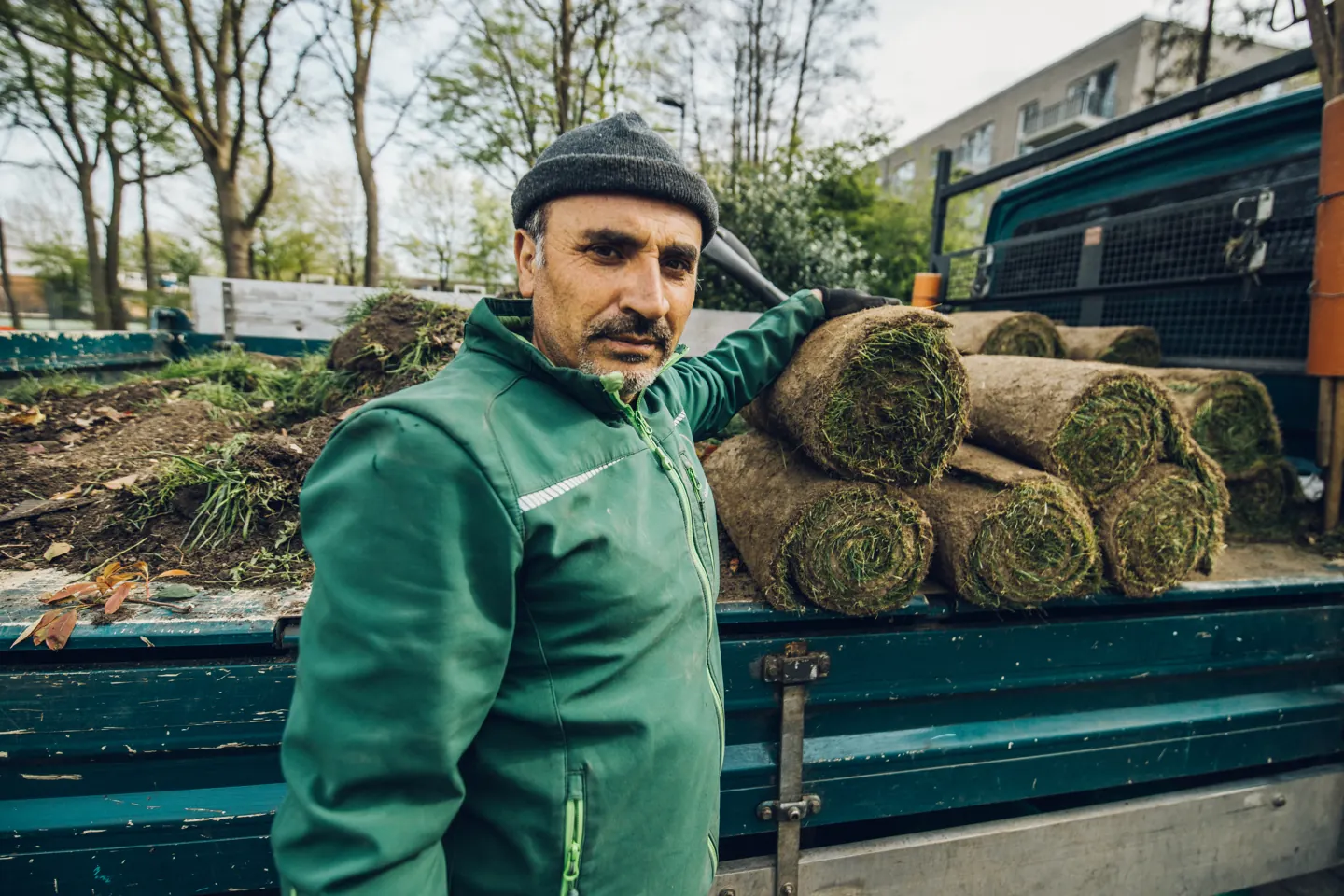 Faik neben Rollrasen auf einem Firmenfahrzeug