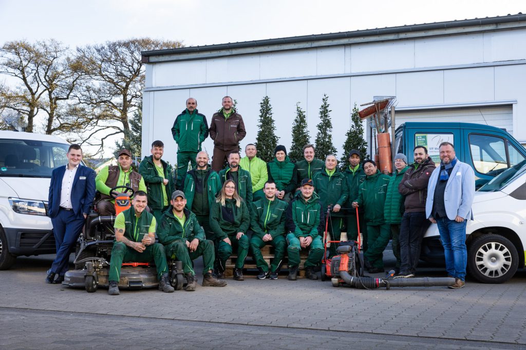 Das Team der Gärtnerei Wohlgemuth vor den Firmenfahrzeugen