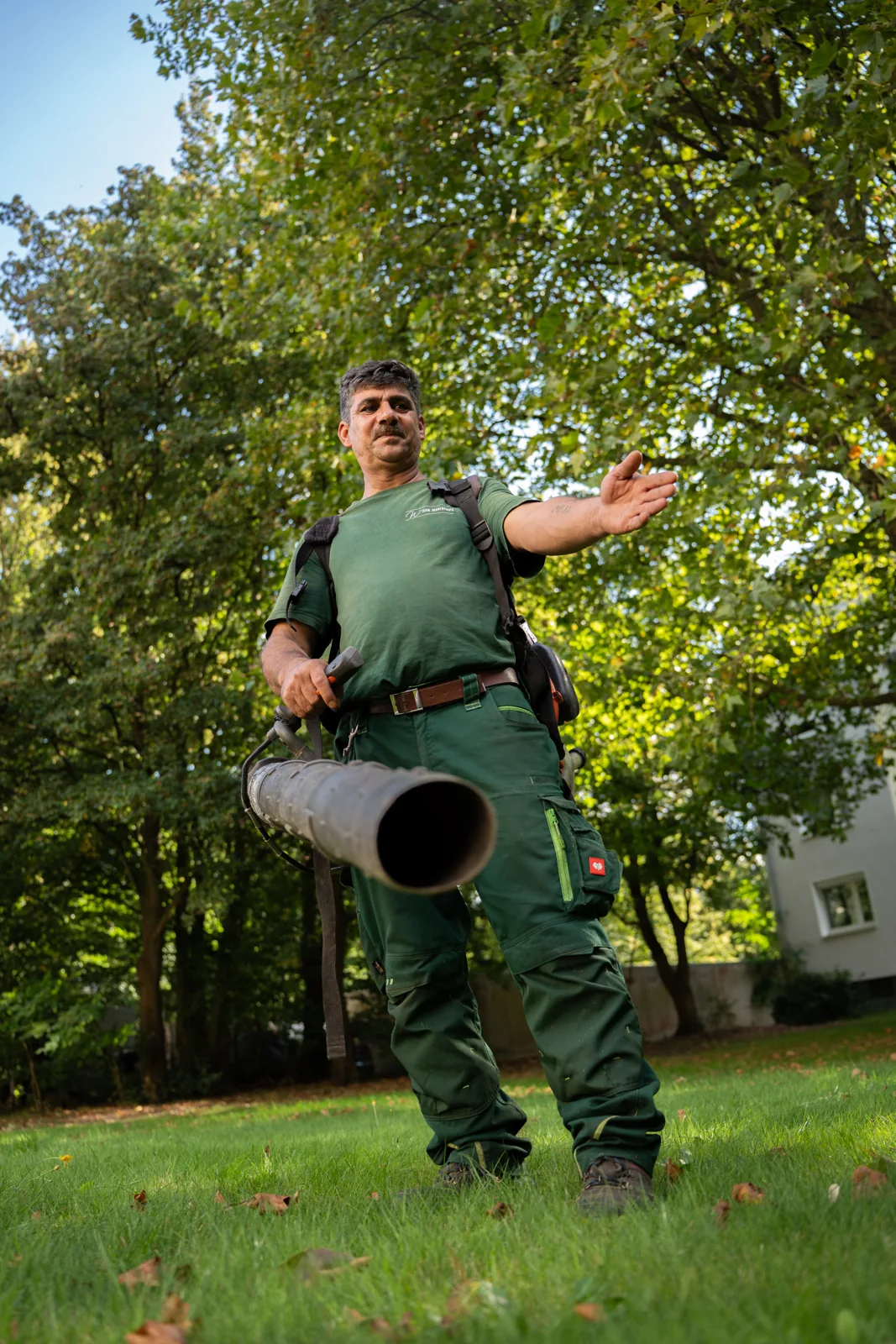 Gärtner mit Laubbläser bei der Saisonpflege